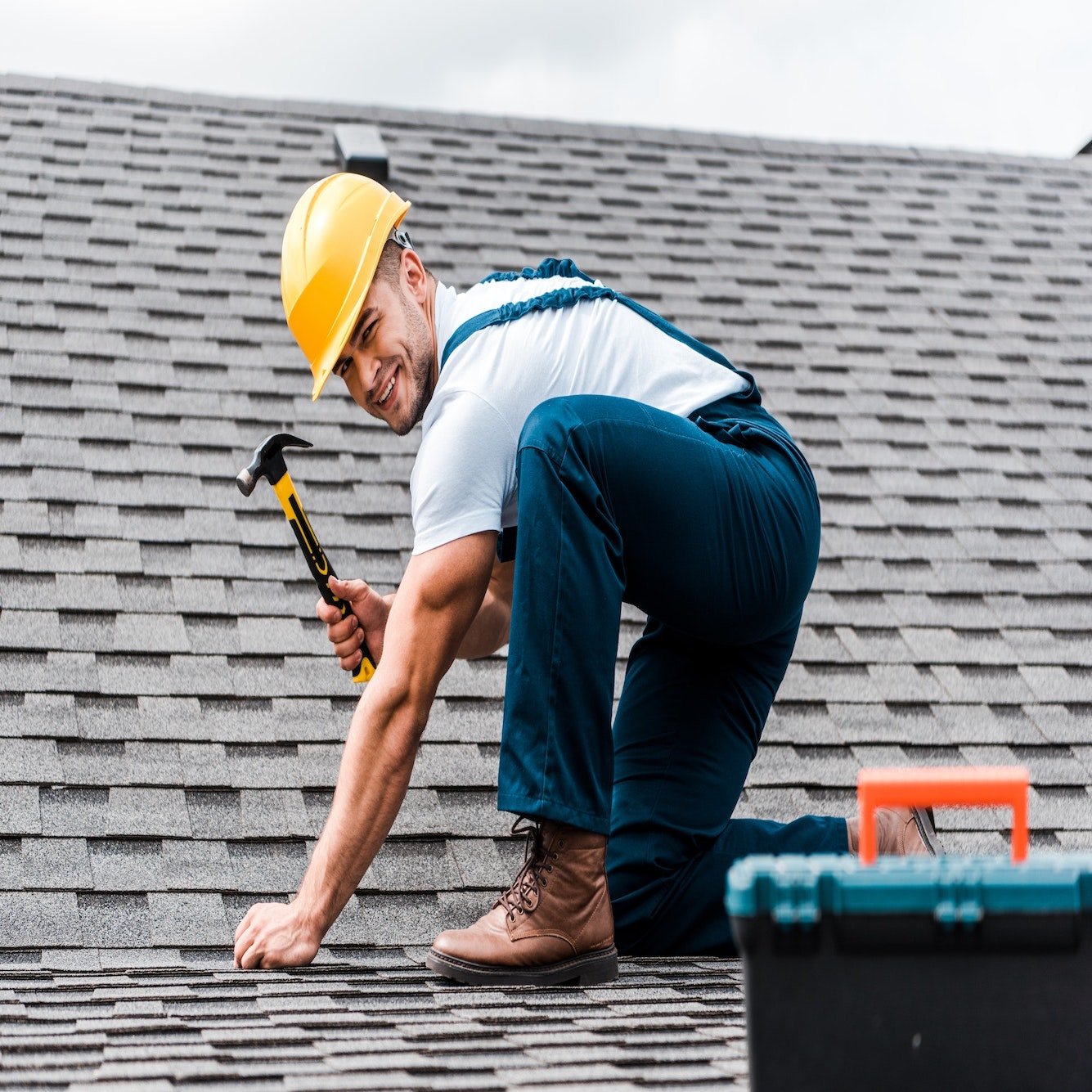 selective-focus-of-handsome-handyman-repairing-roof